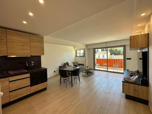 une cuisine avec une table et une salle à manger dans l'établissement Appartement rénové à Cavalaire : 2 pièces, clim, 2 balcons, parking, 1ère étage, centre-ville - FR-1-226B-216, à Cavalaire-sur-Mer
