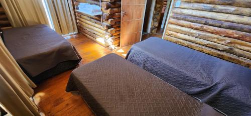 a bedroom with two beds and a wooden floor at Cabin by the Mendoza River in Potrerillos