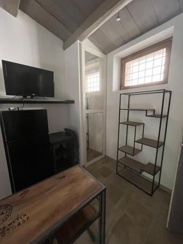 a living room with a tv and a table at Le Mura - rooms and apartments in Norcia