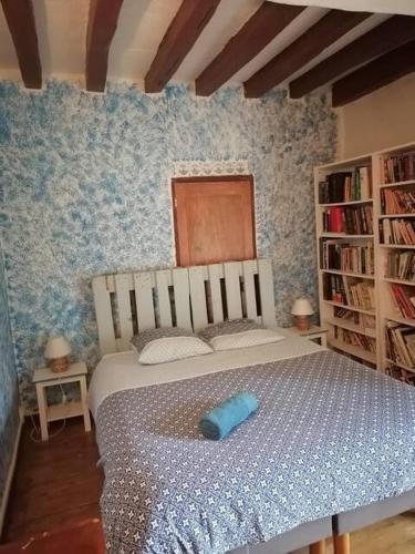 a bedroom with a bed with a blue blanket at Les Ecuries de Montdoucet in Souancé-au-Perche