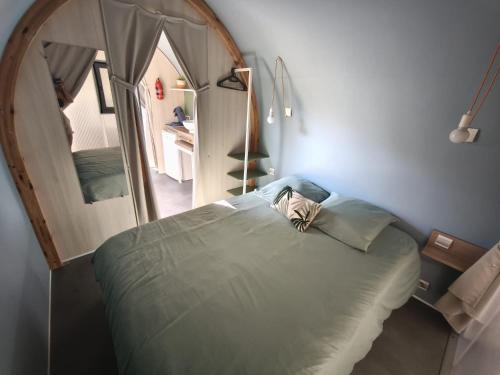 une chambre avec un grand lit avec un grand miroir dans l'établissement Du coté de chez Swann à 150 m de la plage, à Vias