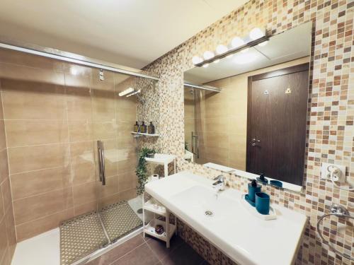 a bathroom with a sink and a shower and a mirror at Cosy Nest - Home cinema, Beach, Mall, TGV station, IPTV, WIFI, AC in Tangier