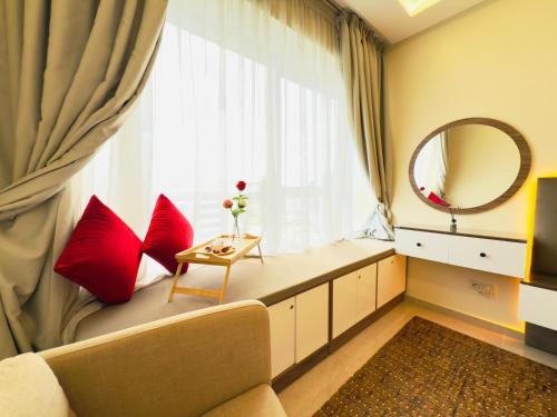 a window seat with red pillows and a mirror at Cosy Nest - Home cinema, Beach, Mall, TGV station, IPTV, WIFI, AC in Tangier
