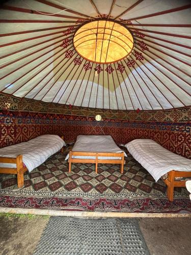 a yurt with two beds and a window in it at Emin Sky Camp in Mineralʼnyy Istochnik Altyn-Arasan