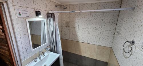 a bathroom with a sink and a mirror at Cabin by the Mendoza River in Potrerillos