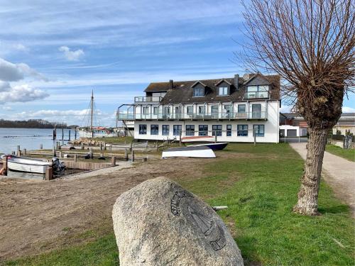 a large building on the shore of a body of water at Ferienwohnung Haus Schleihalle in Maasholm
