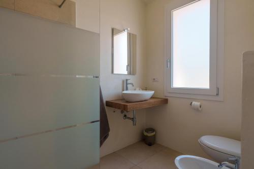 a bathroom with a sink and a mirror at Il Sughereto In Vigna in Aglientu