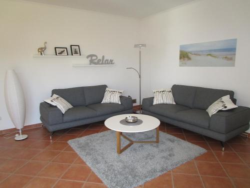 Una sala de estar con dos sofás y una mesa. en Wohnung im Bungalow, en Fehmarn