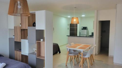 a kitchen and a dining room with a table and chairs at Amplio y moderno monoambiente con lindas vistas en excelente ubicación in Puerto Madryn