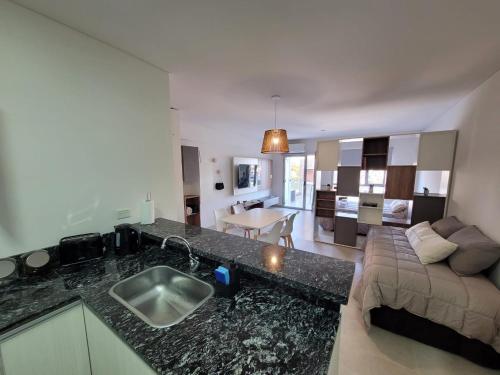 a kitchen and living room with a sink and a couch at Amplio y moderno monoambiente con lindas vistas en excelente ubicación in Puerto Madryn