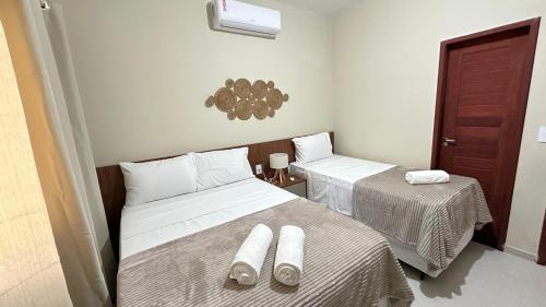 a room with two beds and two tables in it at Chalet Paraíso Lençóis Santo Amaro in Santo Amaro