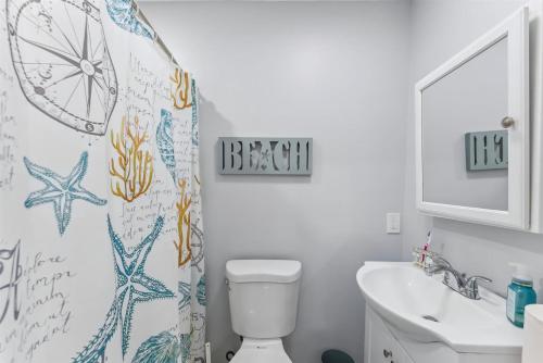 een badkamer met een toilet, een wastafel en een douchegordijn bij 5600 Seaview Ave, Unit 4 in Wildwood Crest