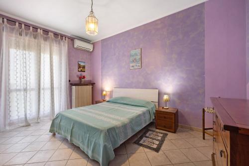 a bedroom with a bed and a purple wall at Casa Carbone in Roddi