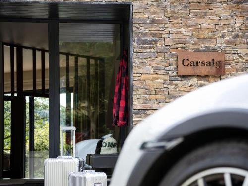 a car parked in front of a brick building at Carsaig in Port of Menteith