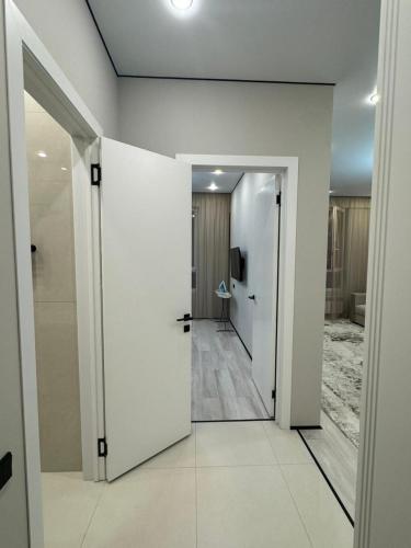 un corridoio con pareti bianche e una porta bianca di Роскошная двухкомнатная квартира a Almaty