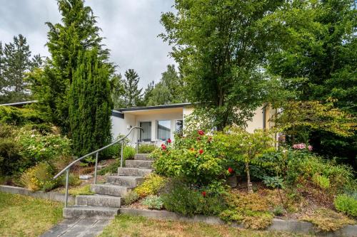 a house with stairs and flowers in front of it at Bungalow 179 in Stelzendorf
