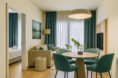 a living room with a couch and a table and chairs at Exklusive Rückzugsorte direkt am türkisblauen See in Villach