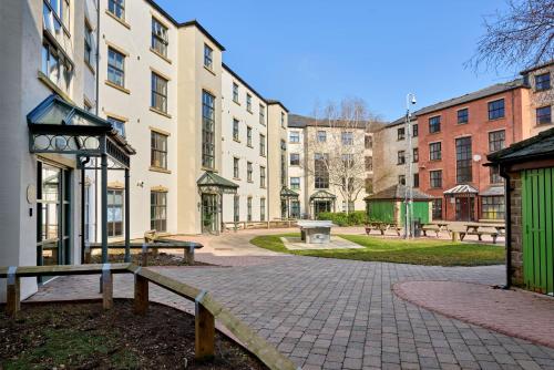 a group of buildings with benches in a park at For Students Only - Snow Island in Huddersfield in Huddersfield
