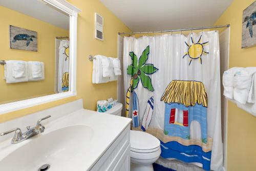 ein Badezimmer mit Toilette und Duschvorhang in der Unterkunft Beach Club #111 in Saint Simons Island