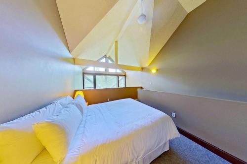 a bedroom with a large white bed with a window at Greystone Lodge 314 in Whistler