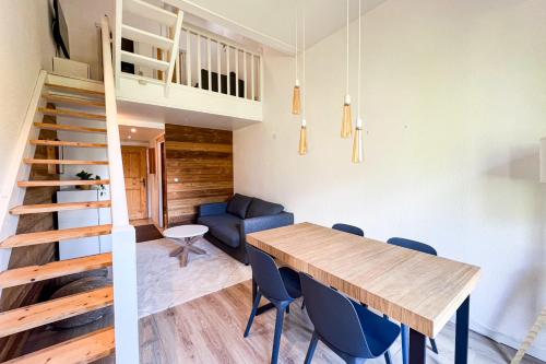 une cuisine et une salle à manger avec une table en bois et des chaises bleues dans l'établissement Cozy apartment with view of Mont Blanc, à Chamonix-Mont-Blanc