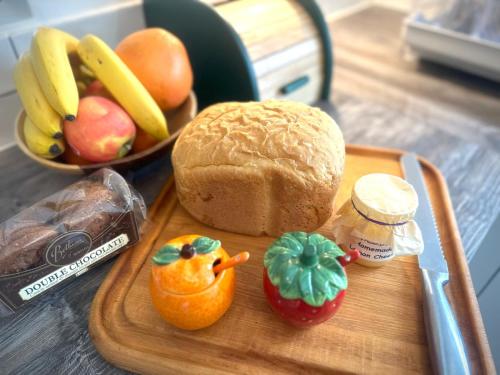 a cutting board with a loaf of bread and a pepper and a stuffed pepper at Muddy Boots-Arcade Royale in Kirkby Stephen