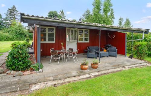 パーストゥイにあるStunning Home In Præstø With Kitchenの赤い家(テーブルと椅子付きのパティオ付)