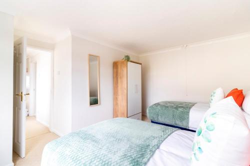 a bedroom with two beds and a mirror at Panoramic Sea View 2 bedroom Sleeps 6-Free Parking in Bournemouth