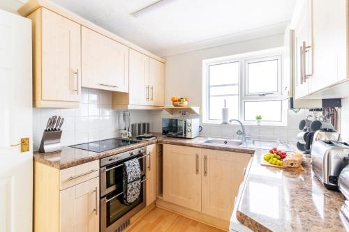 a kitchen with white cabinets and a counter top at Panoramic Sea View 2 bedroom Sleeps 6-Free Parking in Bournemouth