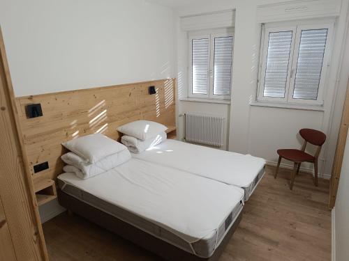 a bedroom with a bed with white sheets and pillows at Grande maison, jusqu’à 14 personnes, calme entre forêt et montagne - FR-1-744-47 in Hohrod