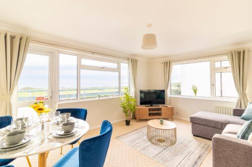 a living room with a table and a couch at Panoramic Sea View 2 bedroom Sleeps 6-Free Parking in Bournemouth