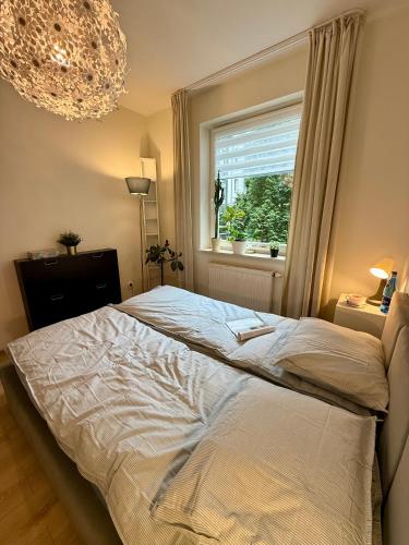 a bedroom with a bed and a window and a chandelier at Kraków Nest in Kraków