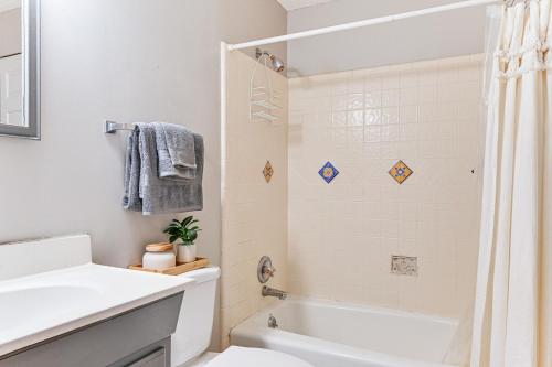 a bathroom with a tub and a sink and a toilet at Launch and Dock Lake Norman Retreat with Scenic Deck in Mooresville