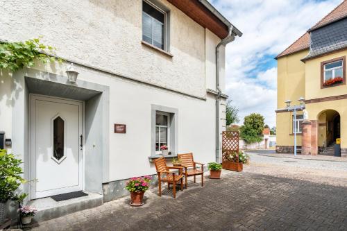 a house with two chairs and a table outside at Gästewohnung Auszeit in Regis-Breitingen