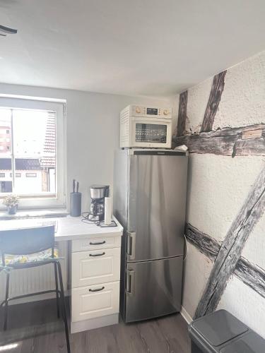 a kitchen with a stainless steel refrigerator and a microwave at 1-Raum Ferienwohnung in Erfurt