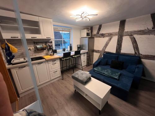 a living room with a blue couch and a kitchen at 1-Raum Ferienwohnung in Erfurt