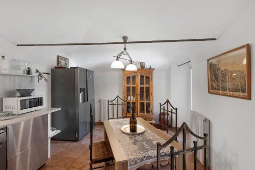 a kitchen with a dining table and a refrigerator at Casa Elisa Montegrazie in Montegrazie
