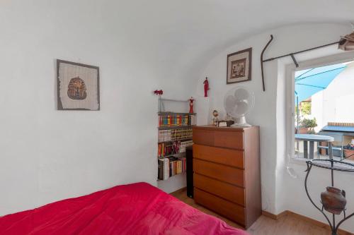 a bedroom with a red bed and a dresser at Casa Elisa Montegrazie in Montegrazie