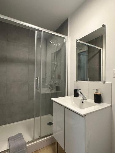 a white bathroom with a shower and a sink at Logement 7 parking gratuit in Poitiers