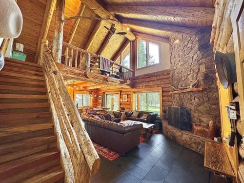 a living room with a couch and a stone wall at Sunriver Log Cabin in Bend