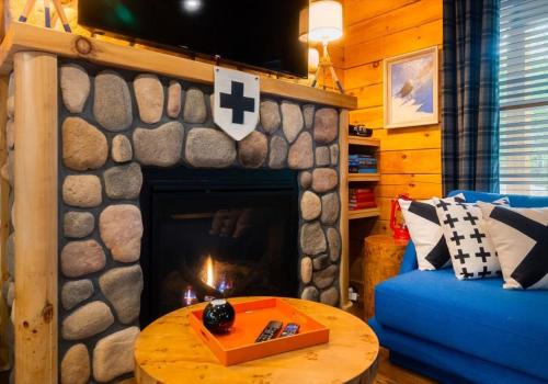 a living room with a fireplace and a blue couch at Chic Designer Log Cabin Hot Tub Pool Tabledecks in McGaheysville
