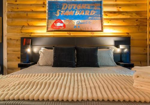 a bedroom with a large bed with a wooden wall at Chic Designer Log Cabin Hot Tub Pool Tabledecks in McGaheysville