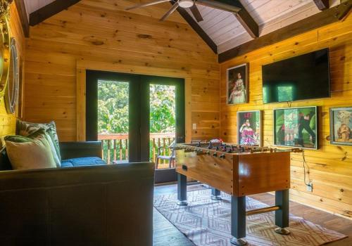 a living room with a pool table and a tv at Chic Designer Log Cabin Hot Tub Pool Tabledecks in McGaheysville