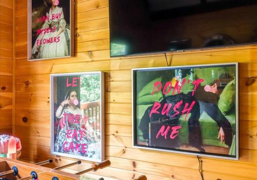two posters on the wall of a room at Chic Designer Log Cabin Hot Tub Pool Tabledecks in McGaheysville