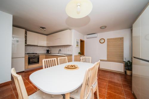 a kitchen and dining room with a white table and chairs at Apartments Barbaresko in Lumbarda