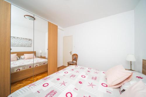 a bedroom with a bed and a mirror at Apartments Barbaresko in Lumbarda