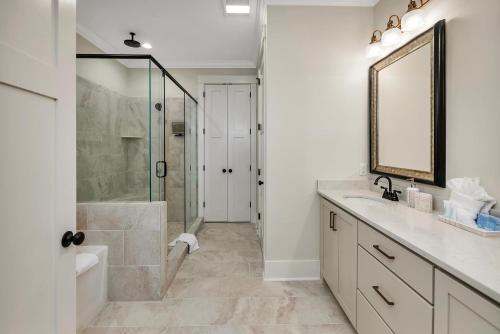 ein Badezimmer mit Dusche, Waschbecken und Spiegel in der Unterkunft The Moorings #35 in Jekyll Island