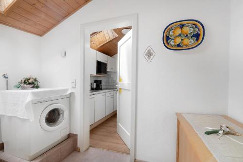 a white laundry room with a washer and dryer at Unterdornerhof Algund in Lagundo