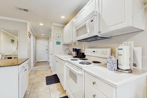 a kitchen with white cabinets and white appliances at Sunset Harbor Palms 2 102 Luzviminda Cove in Navarre