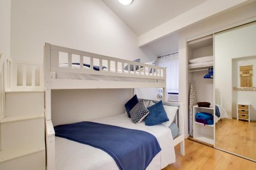 a bedroom with a bunk bed with blue pillows at Saltwater Pool Access Lihue Gem Near Bar and Grill! in Lihue